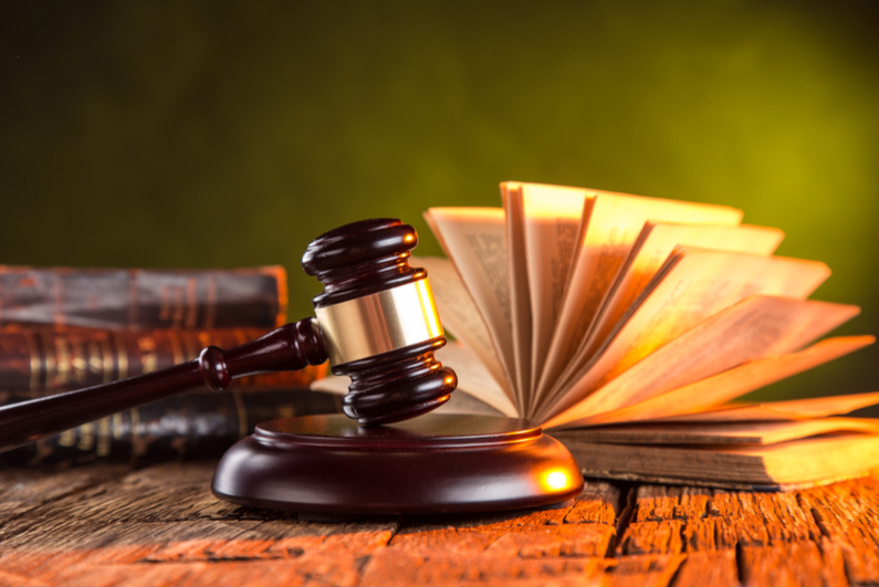 Wooden gavel and books on wooden table