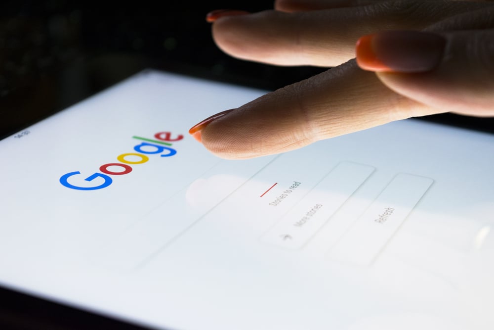 female hands typing into google search on a tablet