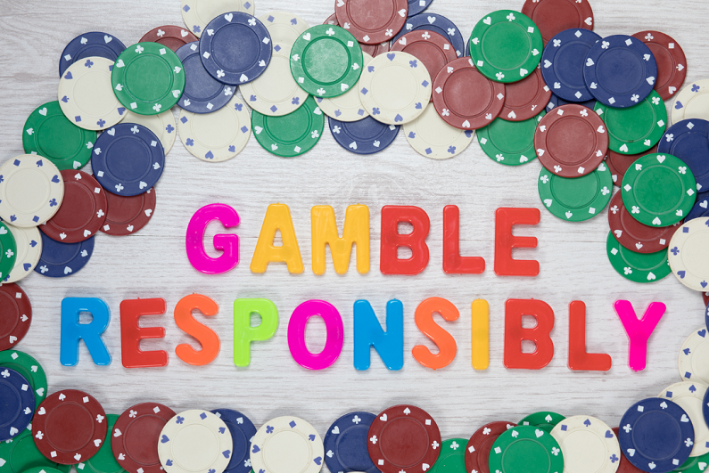 Game responsibly message surrounded by poker chips.