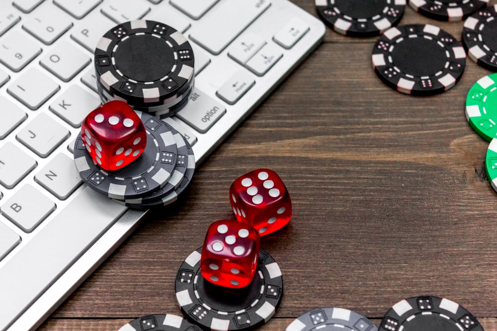 poker chips and dice on a laptop keyoboard