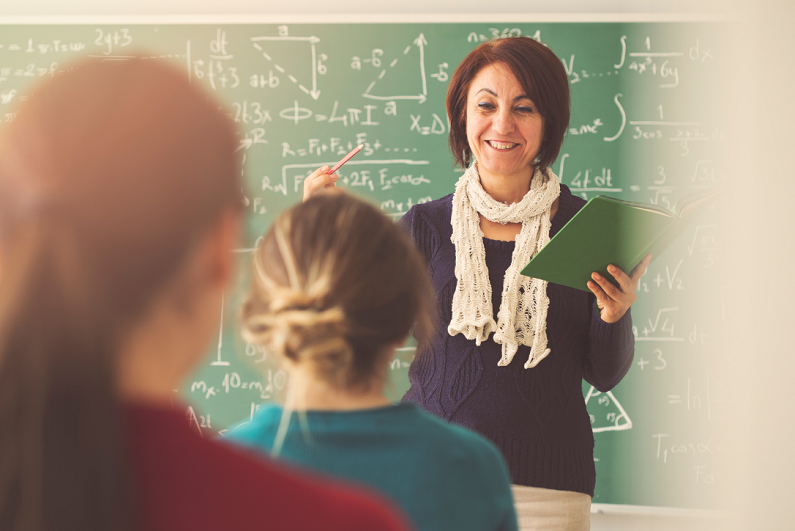 teacher giving lesson to students in classroom