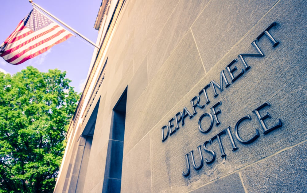 Department of Justice lettering and US flag outside Washington State building