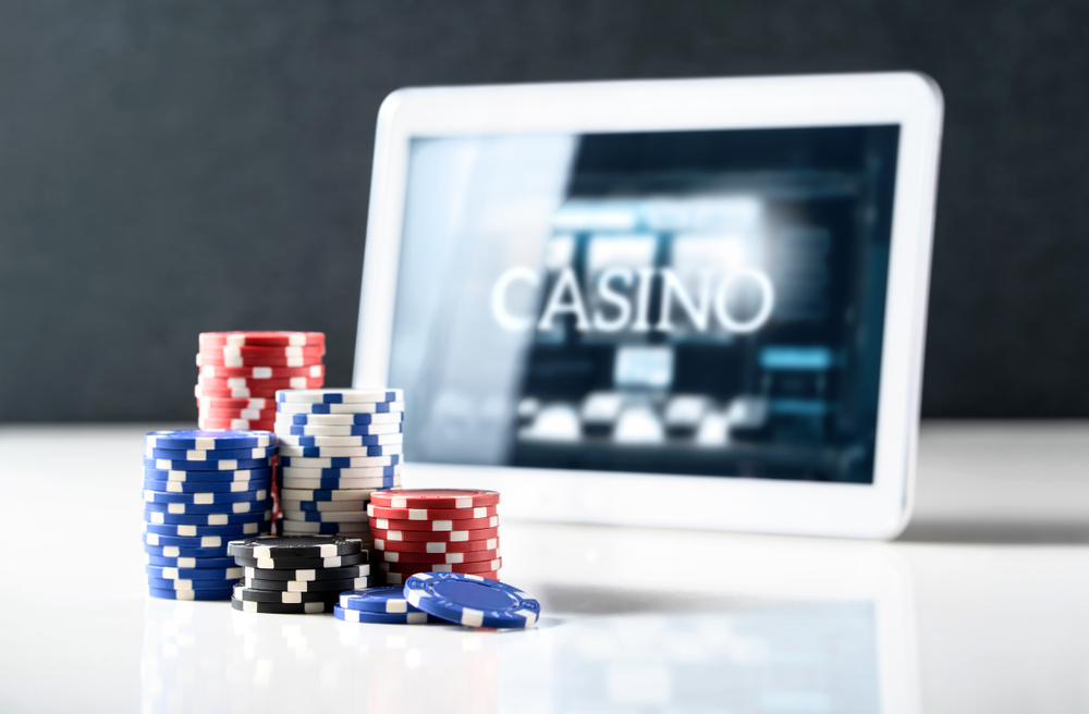 poker chips with ipad showing online casino screen in background