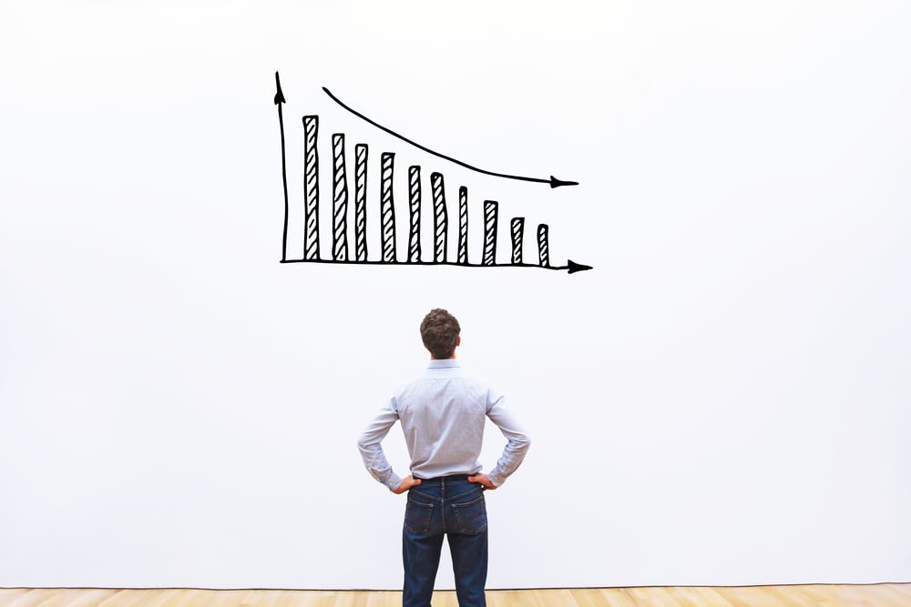 man observing graph showing downtrend and loss