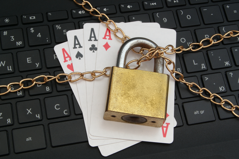 Aces cards placed on computer keyboard and bound by chains and padlock