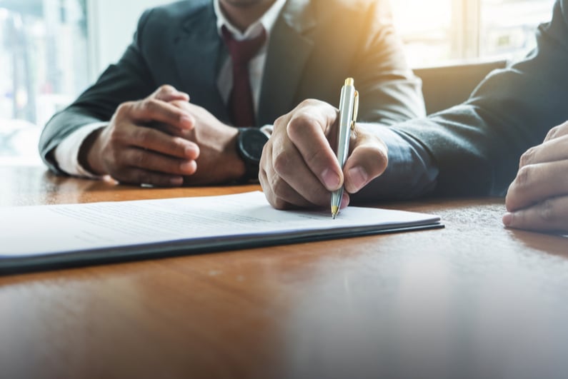 Two businessmen signing a contract