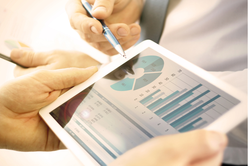 Closeup of two businesspeople looking at charts on a tablet