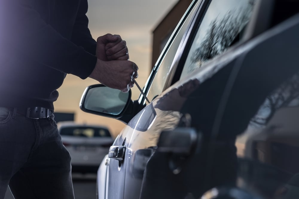 Car thief breaking into a vehicle