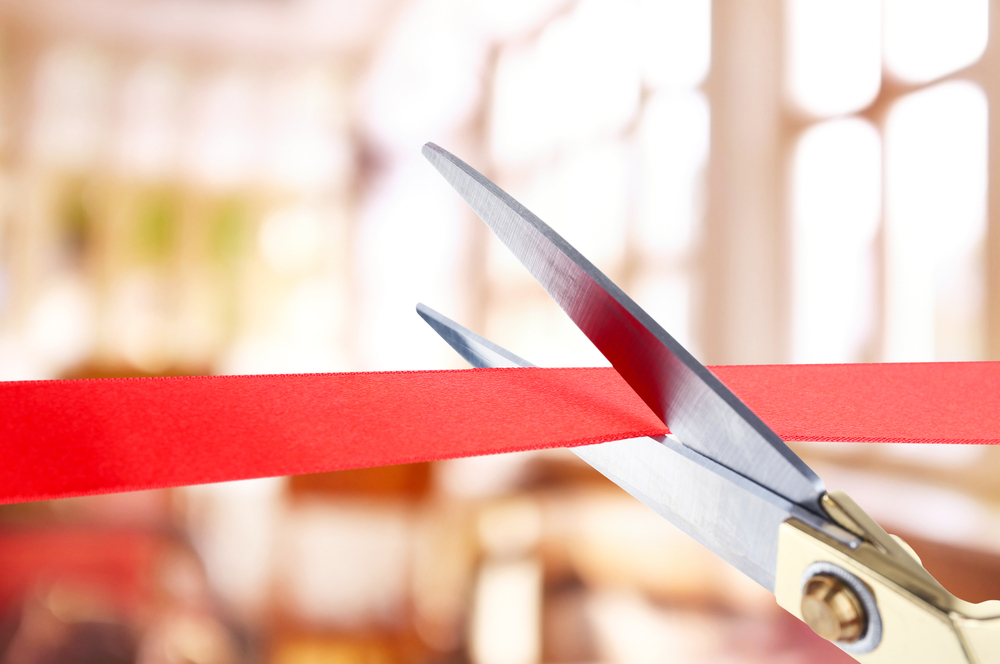 Scissors cutting red ribbon