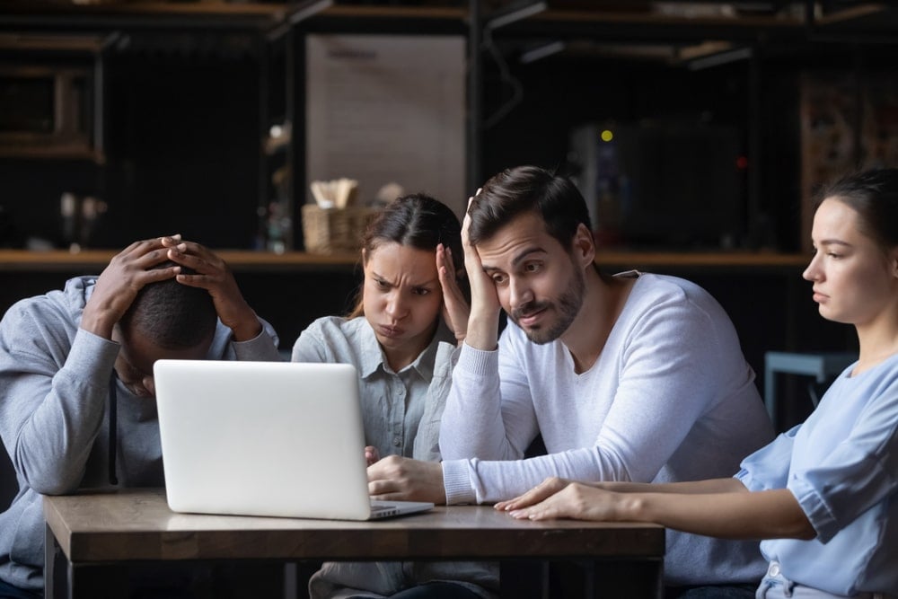 disappointed people looking at a laptop